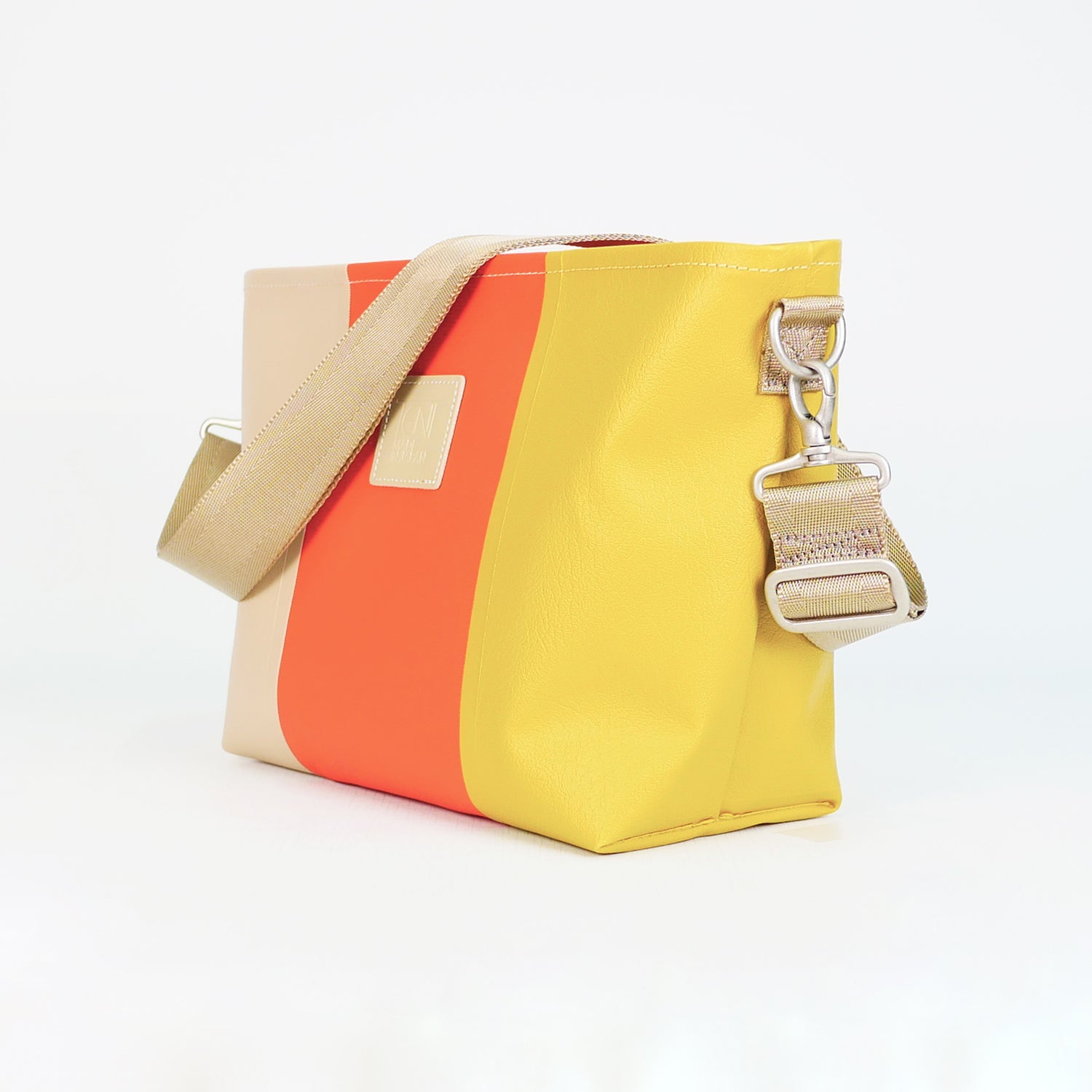 ベージュ、オレンジ、イエローのPVCコーティングポリエステル製2WAYショルダーバッグ斜め全体像。付属ナイロンベルト幅3.8cm、長さ75〜135cmで調整可能。