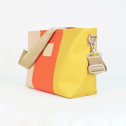 ベージュ、オレンジ、イエローのPVCコーティングポリエステル製2WAYショルダーバッグ斜め全体像。付属ナイロンベルト幅3.8cm、長さ75〜135cmで調整可能。