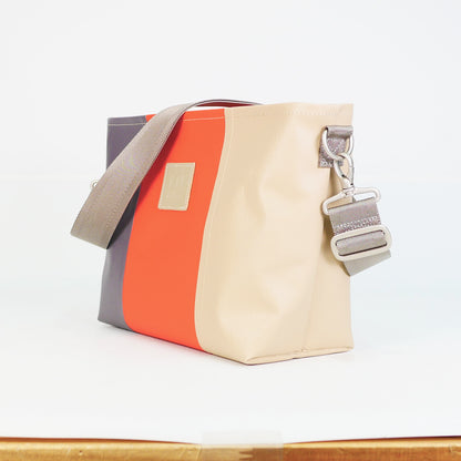 グレー、オレンジ、ベージュの切り返しPVCコーティングポリエステル製2WAYショルダーバッグ斜め全体像。付属ナイロンベルト幅3.8cm、長さ75〜135cmで調整可能。