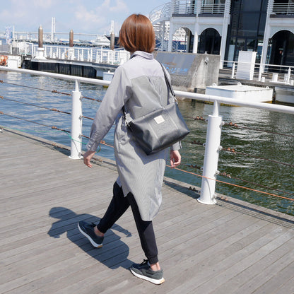 ブラックの身長165cmのモデルがショルダーバッグを肩掛けで着用。上幅35cm×高さ21.5cm×マチ12cmのサイズ感が分かる着用イメージ。