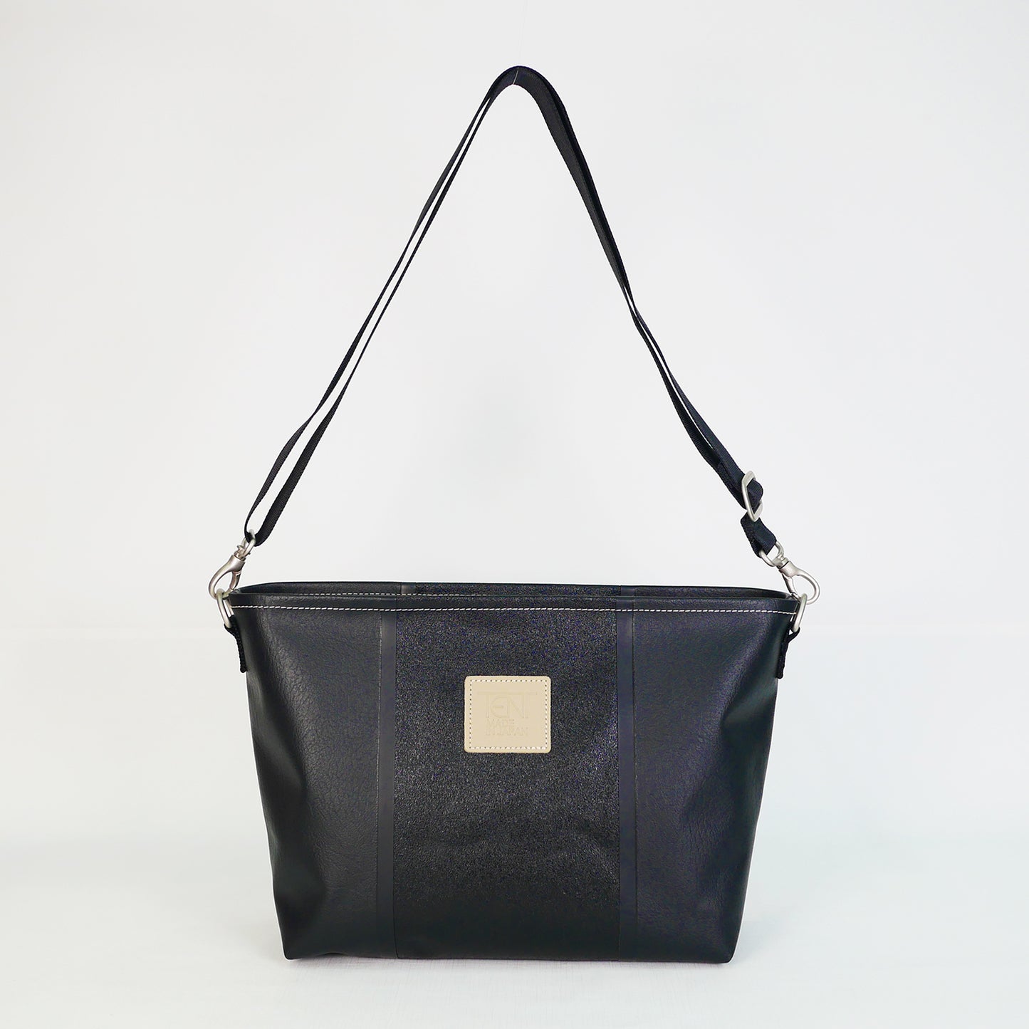 ブラックのPVCコーティングポリエステル製ショルダーバッグ正面。上幅35cm×高さ21.5cm×マチ12cm、重さ435g。高周波ウェルダー加工による防水構造、日本製アップサイクル素材を使用。