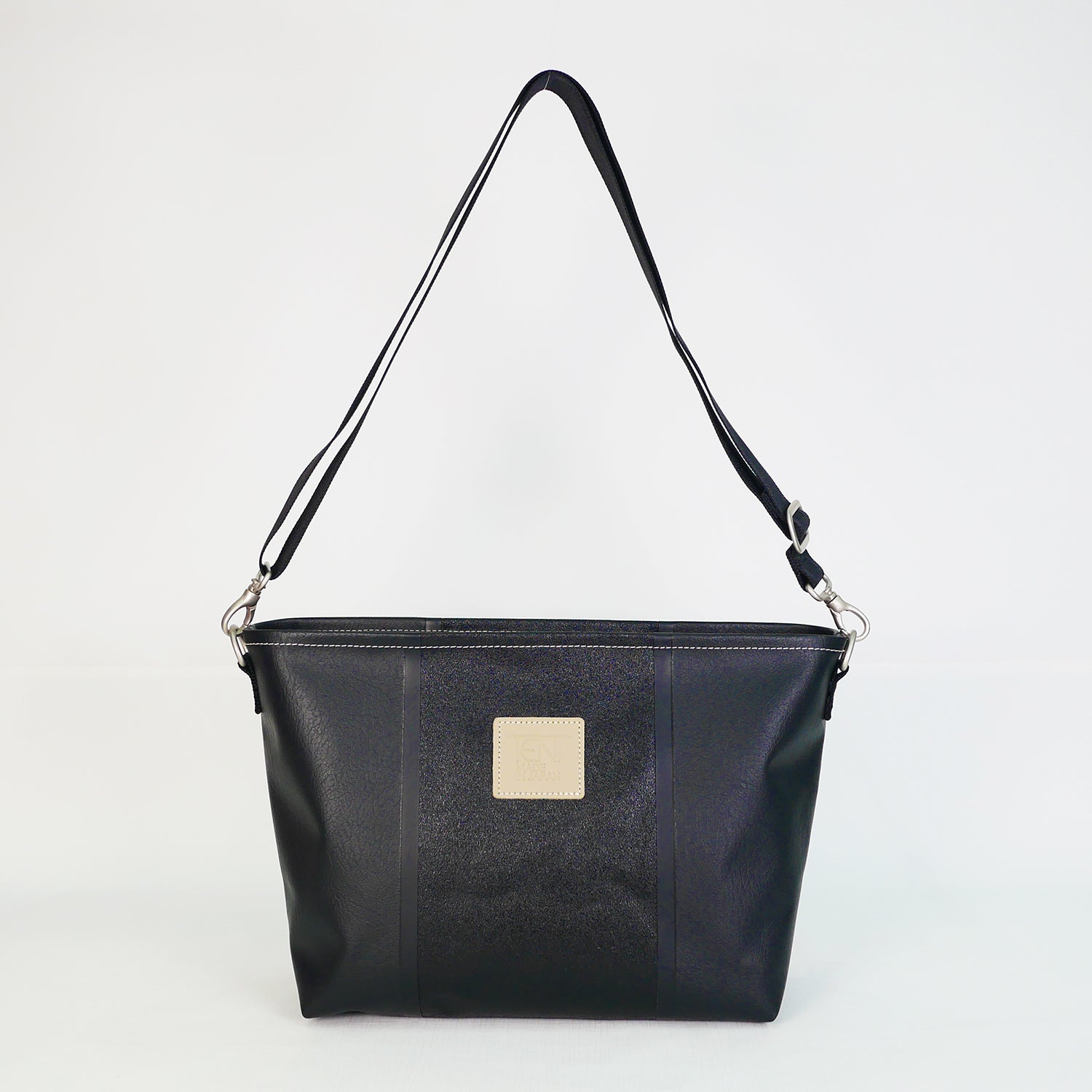 ブラックのPVCコーティングポリエステル製ショルダーバッグ正面。上幅35cm×高さ21.5cm×マチ12cm、重さ435g。高周波ウェルダー加工による防水構造、日本製アップサイクル素材を使用。