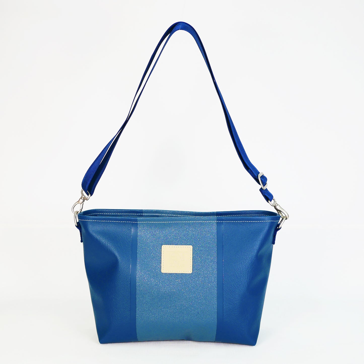 ネイビーのPVCコーティングポリエステル製ショルダーバッグ正面。上幅35cm×高さ21.5cm×マチ12cm、重さ435g。高周波ウェルダー加工による防水構造、日本製アップサイクル素材を使用。